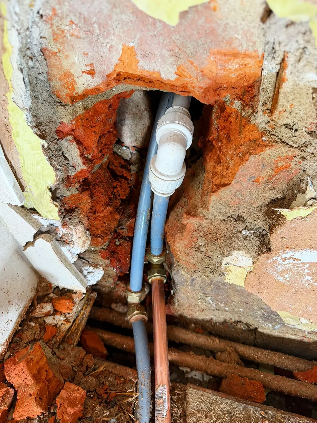 Emergency leak repair on pipework exposed inside a wall at a Manchester property